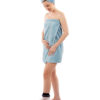 Woman in blue towel, standing up and looking at her left foot which is wearing a LimbO Waterproof Protector on it