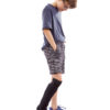 A young boy standing up and wearing a Sealskinz Child's Leg Outdoor Cover on his right leg